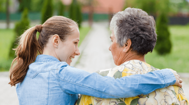 Home carer with her arm around home care user.